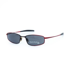 May include: Rectangular sunglasses with a red frame and dark lenses. The temples are red with black tips. The text "REBEL" is printed on the right lens. The sunglasses have a modern, sporty design.