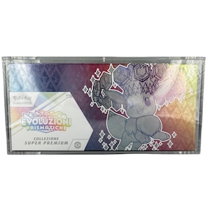 Puede incluir: Una caja sellada del juego de cartas coleccionables Pokémon. La caja presenta un diseño colorido con el texto "EVOLUZIONI PRISMATICHE" y una imagen de dibujos animados de Eevee. La caja está etiquetada como "COLLEZIONE SUPER PREMIUM".