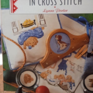 Cani e cuccioli a punto croce. Libro di schemi in inglese. Trovato in Francia.