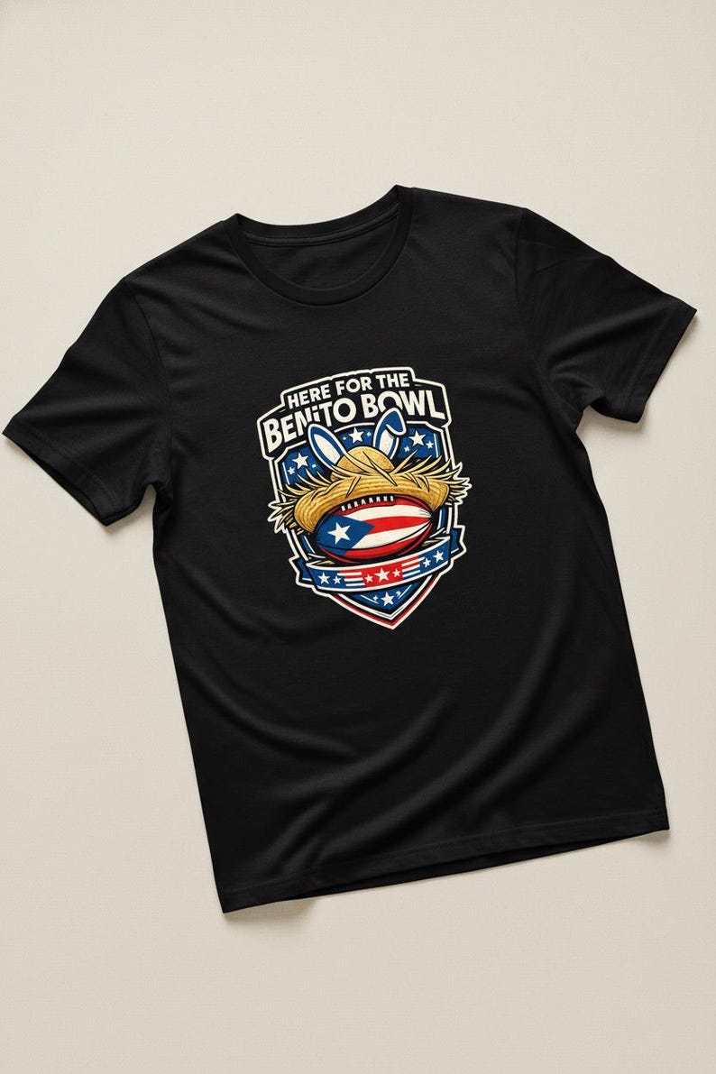 May include: Black t-shirt with a graphic featuring a football wearing a straw hat and bunny ears, with the text "HERE FOR THE BENITO BOWL". The design incorporates the Puerto Rican flag and stars.