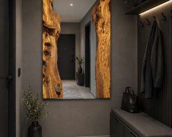 May include: A rectangular wall mirror featuring a central reflective glass panel flanked by two vertical, natural-edged live edge wood slabs with a warm brown grain pattern, mounted on a dark gray wall in a hallway setting.