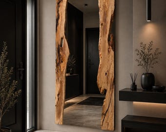 May include: A tall, rectangular wall mirror featuring a natural live-edge wood frame on the left and right sides. The wood displays a light brown grain with dark, organic knots and irregular, raw edges that contrast with the reflective glass surface.