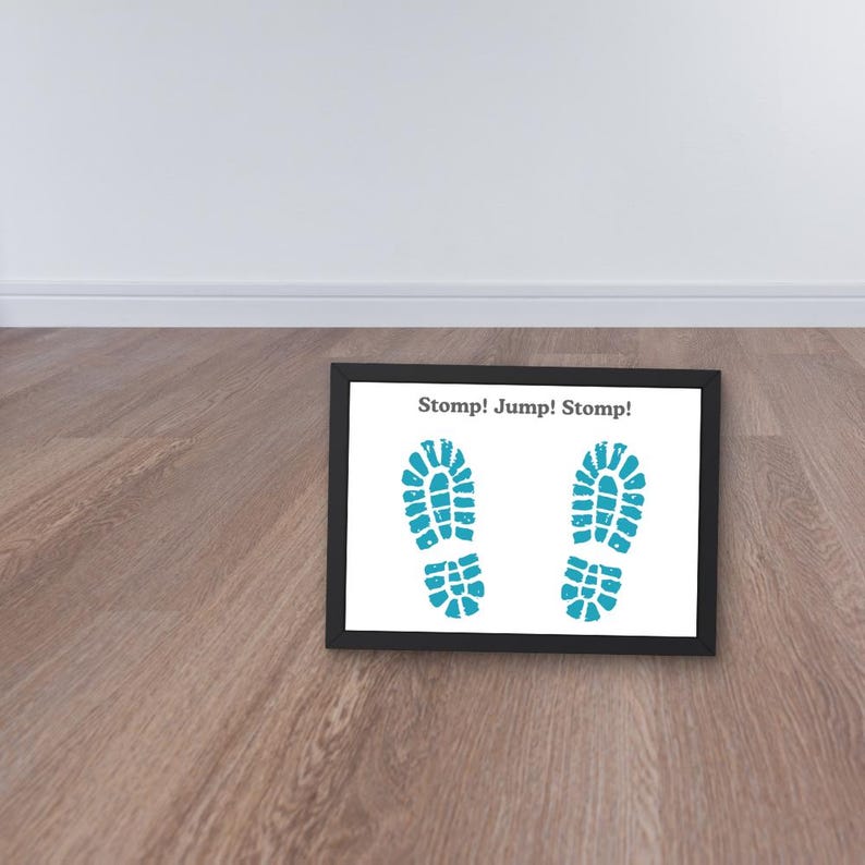 May include: A framed print featuring two turquoise footprints on a white background. The text "Stomp! Jump! Stomp!" is printed above the footprints in black. The frame is black.