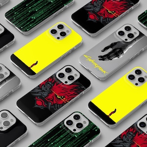 May include: A selection of smartphone cases with diverse designs. Some cases are yellow, black, or grey. Graphics include a red and black illustration, a hand, and a green matrix pattern. The text "Cyberpunk" is visible on some cases.