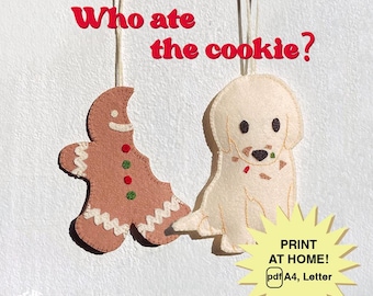 May include: Felt Christmas ornaments featuring a gingerbread man and a dog, with the text "Who ate the cookie?" The gingerbread man is missing a bite, and the dog has crumbs on its mouth. The ornaments are hanging from strings.