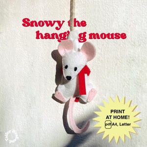 May include: A handmade felt mouse ornament with a red scarf and pink ears and feet. The mouse is hanging from a string against a white background. Text above reads "Snowy the hanging mouse". A yellow starburst graphic says "PRINT AT HOME! pdf A4, Letter".