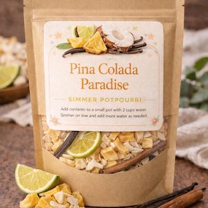 May include: A brown paper bag with a clear window displaying a simmer potpourri mix. The label reads "Pina Colada Paradise." Ingredients include dried pineapple, coconut, lime slices, vanilla beans, and cinnamon sticks. Instructions are printed on the label.