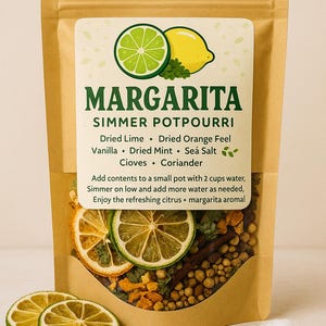 May include: A brown paper bag labeled "Margarita Simmer Potpourri" with a lime and lemon graphic. The bag contains dried lime slices, orange peel, vanilla, mint, sea salt, cloves, and coriander. Instructions are printed on the label.