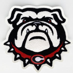 May include: Embroidered patch featuring a bulldog's head. The patch has a white background with a black and white bulldog design. The bulldog has red eyes and a red collar with a white and red "G" emblem. The patch is approximately 4 inches wide.