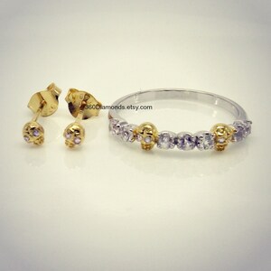 May include: A set of gold skull earrings and a silver ring with gold skull accents and clear cubic zirconia stones. The ring has the text "360Diamonds.etsy.com" on it.