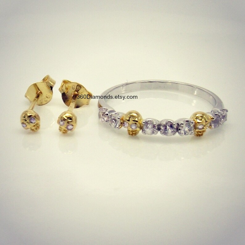 May include: A set of gold skull earrings and a silver ring with gold skull accents and clear cubic zirconia stones. The ring has the text "360Diamonds.etsy.com" on it.