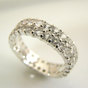 May include: A silver band ring with a double row of clear cubic zirconia stones.