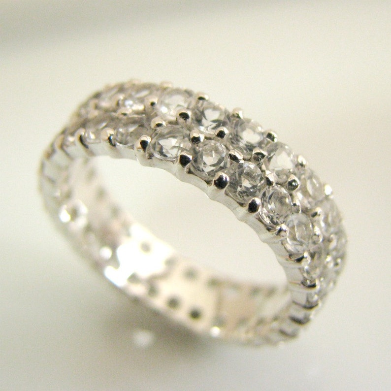May include: A silver band ring with a double row of clear cubic zirconia stones.