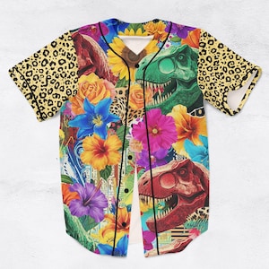 May include: A baseball jersey with a colourful floral and dinosaur design. The jersey features a mix of flowers, including hibiscus and roses, and dinosaur illustrations. The sleeves have a leopard print pattern.