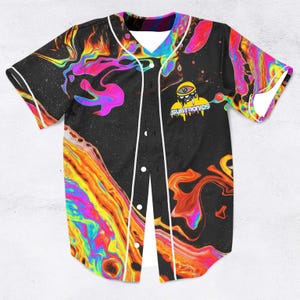 May include: Black baseball jersey with a swirling, colourful design in orange, yellow, pink, and purple. The jersey has white trim, a button-up front, and the text "SUBTRONICS" with a cartoon eye graphic.