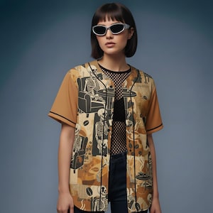 May include: A baseball jersey with a unique coffee-themed design. The jersey features a tan and brown color scheme with a pattern of coffee beans, skeletons, and coffee shop scenes. The sleeves are solid tan with black trim.