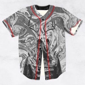 May include: Baseball jersey featuring a black and white marbled pattern and a horned skull graphic. The jersey has a cream-coloured collar and cuffs, with red trim along the seams and button placket.