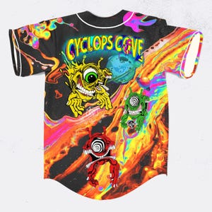 May include: Black baseball jersey with a vibrant, psychedelic design. The jersey displays the text "CYCLOPS COVE" and cartoon cyclops characters. The background features a swirling, fiery pattern with a planet.