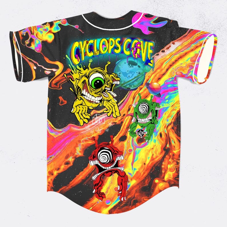 May include: Black baseball jersey with a vibrant, psychedelic design. The jersey displays the text "CYCLOPS COVE" and cartoon cyclops characters. The background features a swirling, fiery pattern with a planet.
