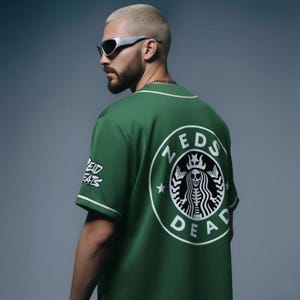 May include: Green baseball jersey with white trim and the text "ZEDS DEAD" in a circular logo on the back. The logo features a skeleton with a crown. The left sleeve has the text "EAT FATS".