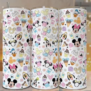 May include: Three white insulated tumblers with a repeating pattern of Disney characters and icons. The design includes Mickey and Minnie Mouse, Donald Duck, Goofy, ice cream cones, and castle images. The tumblers have a silver straw.
