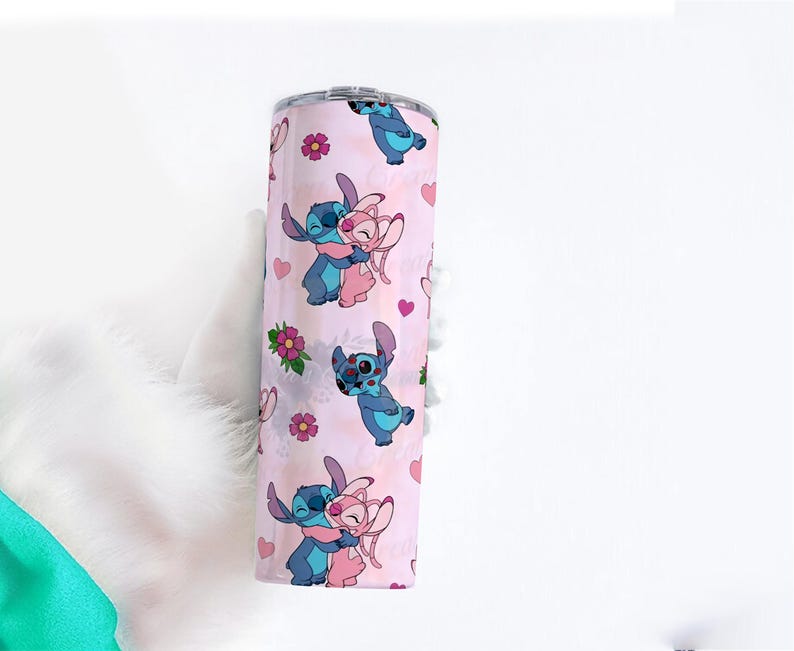 Peut inclure: Un gobelet en acier inoxydable avec un fond rose orn&eacute; d'un motif r&eacute;p&eacute;t&eacute; de personnages de dessins anim&eacute;s bleus et roses, de c&oelig;urs et de fleurs. Les personnages s'embrassent. Le gobelet est cylindrique.