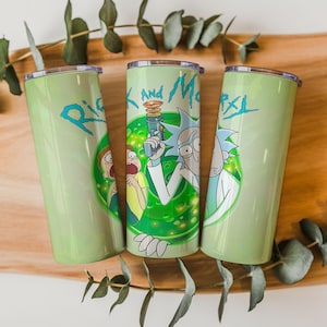 May include: A white ceramic mug with a black handle and the text "But First, Coffee" in a bold, black font. The mug is set against a blurred background, suggesting a cozy setting.