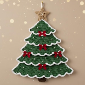 Puede incluir: Un adorno de pared de árbol de Navidad hecho a mano, de ganchillo verde. El árbol está decorado con lazos rojos y cuentas blancas con aspecto de perlas. Una estrella dorada corona el árbol y los bordes están ribeteados con hilo blanco.