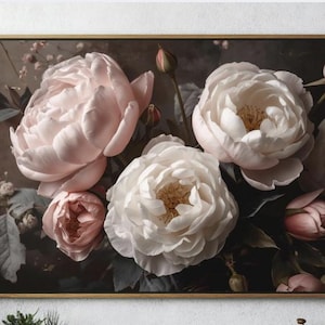 May include: A framed floral print featuring large, lush peonies in shades of white and blush pink. The flowers are set against a dark, moody background, creating a dramatic contrast. The artwork is displayed above a wooden console table.