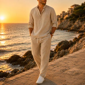 May include: A beige long-sleeved linen shirt with a partial button placket and matching beige linen trousers. The shirt features a mandarin collar and rolled-up sleeves, while the trousers have a drawstring waist and a relaxed, straight-leg fit.