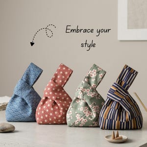 Könnte beinhalten: Vier Stoffbeutel mit Knotenverschluss und verschiedenen Mustern: blaue Wellen, rote Geometrie, grüne Kirschblüten und marineblaue Streifen. Der Text "Embrace your style" mit einem gestrichelten Pfeil ist darüber zu sehen.