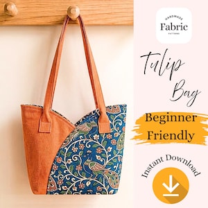 May include: A tote bag featuring a solid orange fabric panel on the left and a blue fabric panel with a repeating peacock and floral pattern on the right. The bag has two orange shoulder straps and a curved top opening. Text includes Tulip Bag.