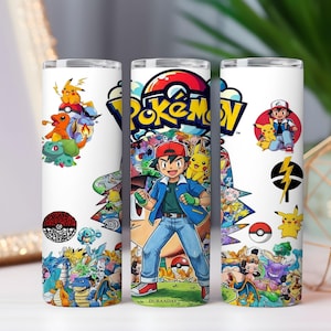 Può includere: Un bicchiere cilindrico bianco con una stampa colorata che avvolge l'intera superficie, raffigurante vari personaggi Pokemon tra cui Pikachu, Bulbasaur e Charmander, insieme alla figura centrale di Ash Ketchum e al logo Pokemon giallo e blu.