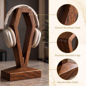 May include: A wooden headphone stand with a geometric, elongated hexagonal frame and a rectangular base. The stand features a natural Sheesham grain, precision rounded edges, and a smooth satin finish. Light-colored headphones rest on the stand.
