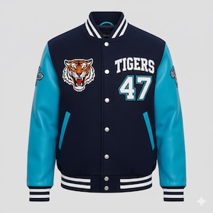 Könnte beinhalten: Marineblaue und türkisfarbene Collegejacke mit einem Tiger-Patch und dem Schriftzug "Tigers 47". Die Jacke hat türkisfarbene Ärmel, weiße Streifen an Kragen, Bündchen und Saum sowie einen Knopfverschluss.