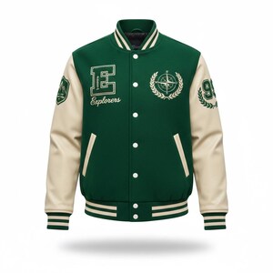 Könnte beinhalten: Grün-cremefarbene Collegejacke mit dem Wort "Explorers" und einem Kompassrosen-Design. Die Jacke hat cremefarbene Ärmel, einen grünen Körper und gestreifte Bündchen und Saum. Aufnäher auf den Ärmeln zeigen einen Berg und die Zahl "93".