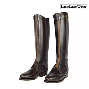 May include: A pair of tall, dark brown riding boots with gold-colored zippers and buckles. The boots have a classic design with a smooth leather finish and are suitable for equestrian activities. The brand name "LaceLuxeWear" is visible.
