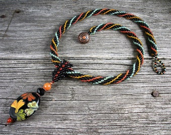 SOLD! Beadweaving: African Helix Rope with Floral Lampwork Pendant in Black, Orange, Green, Yellow