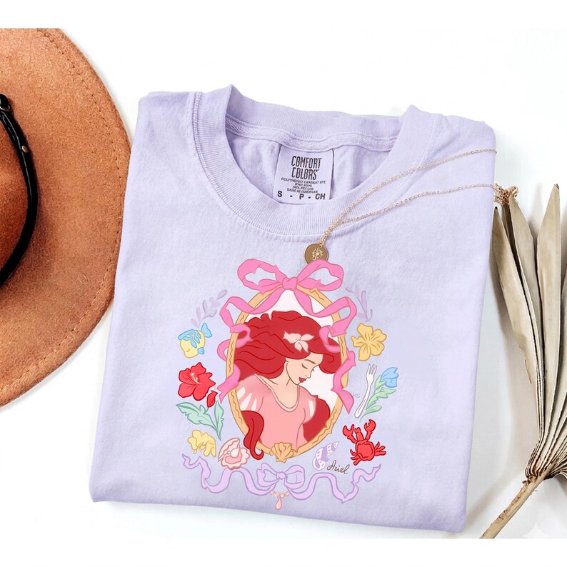 May include: A white ceramic mug with a black handle and the text "But First, Coffee" in a black, handwritten-style font. The mug is on a white surface.