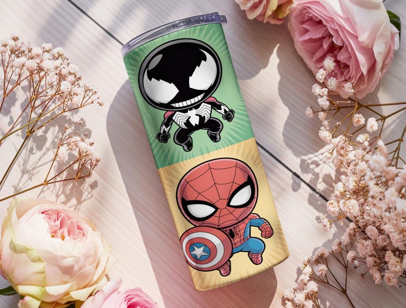 May include: A tall, insulated tumbler featuring cartoon illustrations of Venom and Spider-Man. The tumbler has a green and yellow background with the characters in a chibi style. The tumbler is cylindrical and has a silver lid.