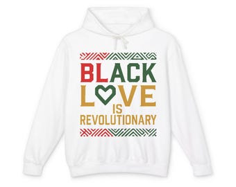 Peut inclure: Un sweat à capuche blanc avec l'inscription "BLACK LOVE IS REVOLUTIONARY" en rouge, vert et or. Le motif comprend des motifs géométriques décoratifs en rouge, vert et blanc. Le sweat à capuche a un cordon de serrage et une poche avant.