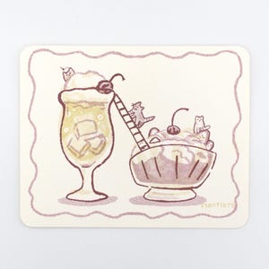 May include: A rectangular sticker with rounded corners featuring a light purple outline. The illustration shows a tall glass of yellow drink and a bowl of dessert, both topped with cherries and small cats, connected by a small ladder. Text reads Plantlers.