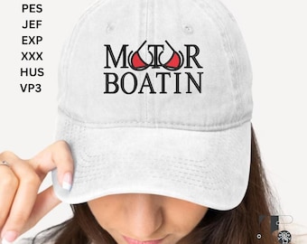 May include: White baseball cap with the text "MOTOR BOATIN" in black letters. The "O" in MOTOR is replaced with a red bikini top graphic. The cap is worn by a person.