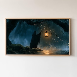 May include: A rectangular wall art print in a light wood frame depicting a dark, hooded figure standing in a misty forest at night. The figure holds a glowing lantern that illuminates the surrounding fog and floating golden particles of light.