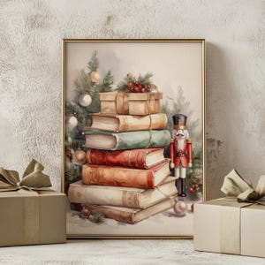以下が含まれることがあります： クリスマスをテーマにした、本とプレゼントの山が描かれた額入りの水彩画プリント。背景にはクリスマスツリーとオーナメントがあり、本の隣にはおもちゃのくるみ割り人形が立っています。本は赤、緑、茶色の色合いです。