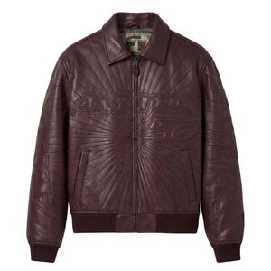 May include: A burgundy leather jacket with a zip-up front, collar, and ribbed cuffs and hem. The jacket features the embossed text "Avirex 50" on the chest and sleeves, with a sunburst design radiating from the center.
