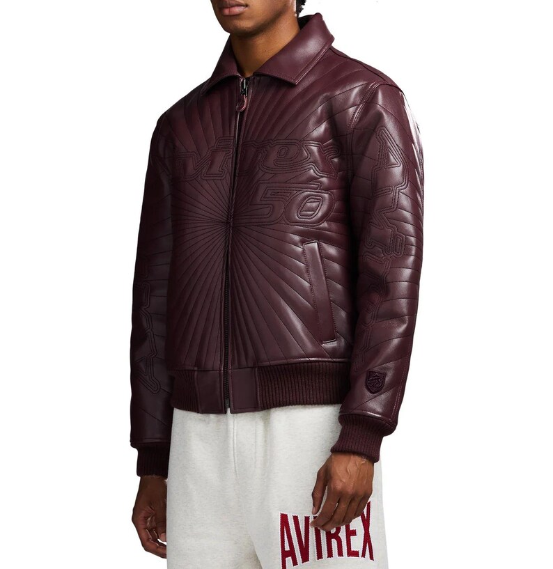 May include: A burgundy leather jacket with a quilted design and a zip-up front. The jacket features the text "VINTAGE 50" across the chest and a ribbed hem and cuffs. The jacket is paired with gray sweatpants.