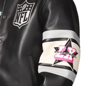 Puede incluir: Chaqueta de cuero negra con el parche del logo de la NFL en el pecho. La manga presenta un dise&ntilde;o blanco, gris y negro con el texto "SUPER BOWL LX" en rosa. La chaqueta tiene cierre de botones.
