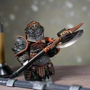 Puede incluir: Figura detallada de un caballero medieval con armadura completa, sosteniendo un hacha de batalla. La armadura es una mezcla de plata y bronce, con intrincados diseños en el casco y el pecho. El hacha tiene un mango negro y una hoja plateada.