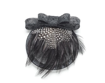 Black and white polkadot fascinator with bow.  Hand made using natural British guinea fowl feathers